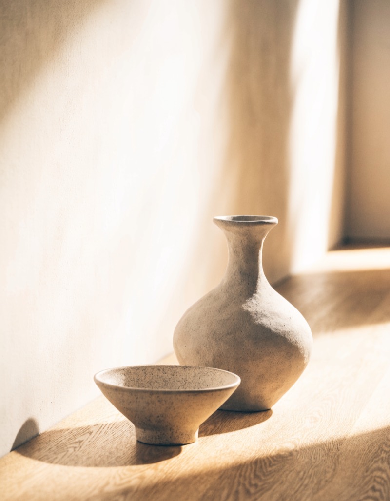 Keramikvase und Steingutschale auf heller Eiche